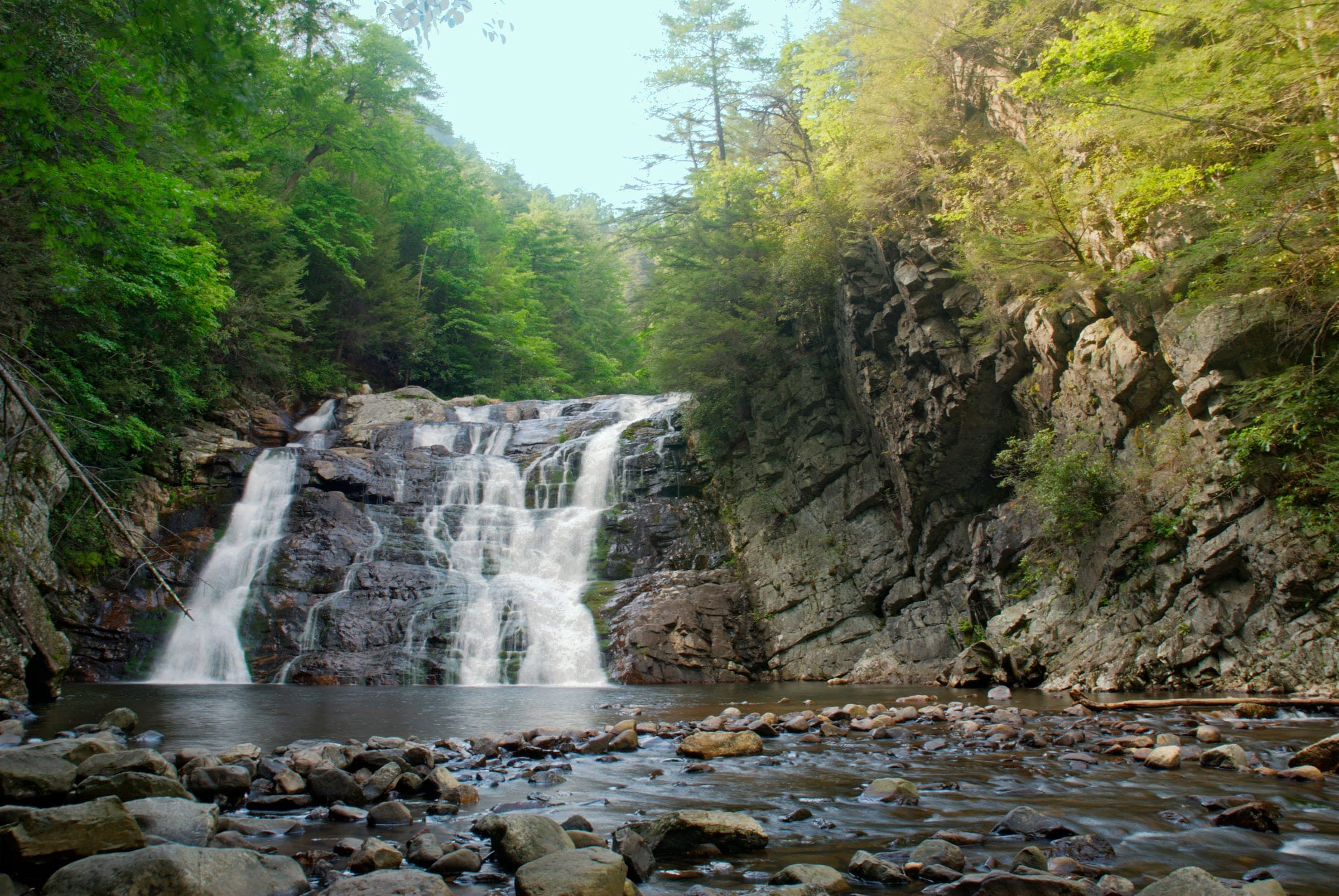 Laurel Fork Falls spilling in white braids over dark ledges into a rocky pool walled by cliffs