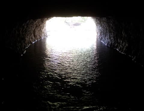 River water rushing through the rough-hewn rock interior of the Pattison Forge tunnel, cut through the ridge around 1820