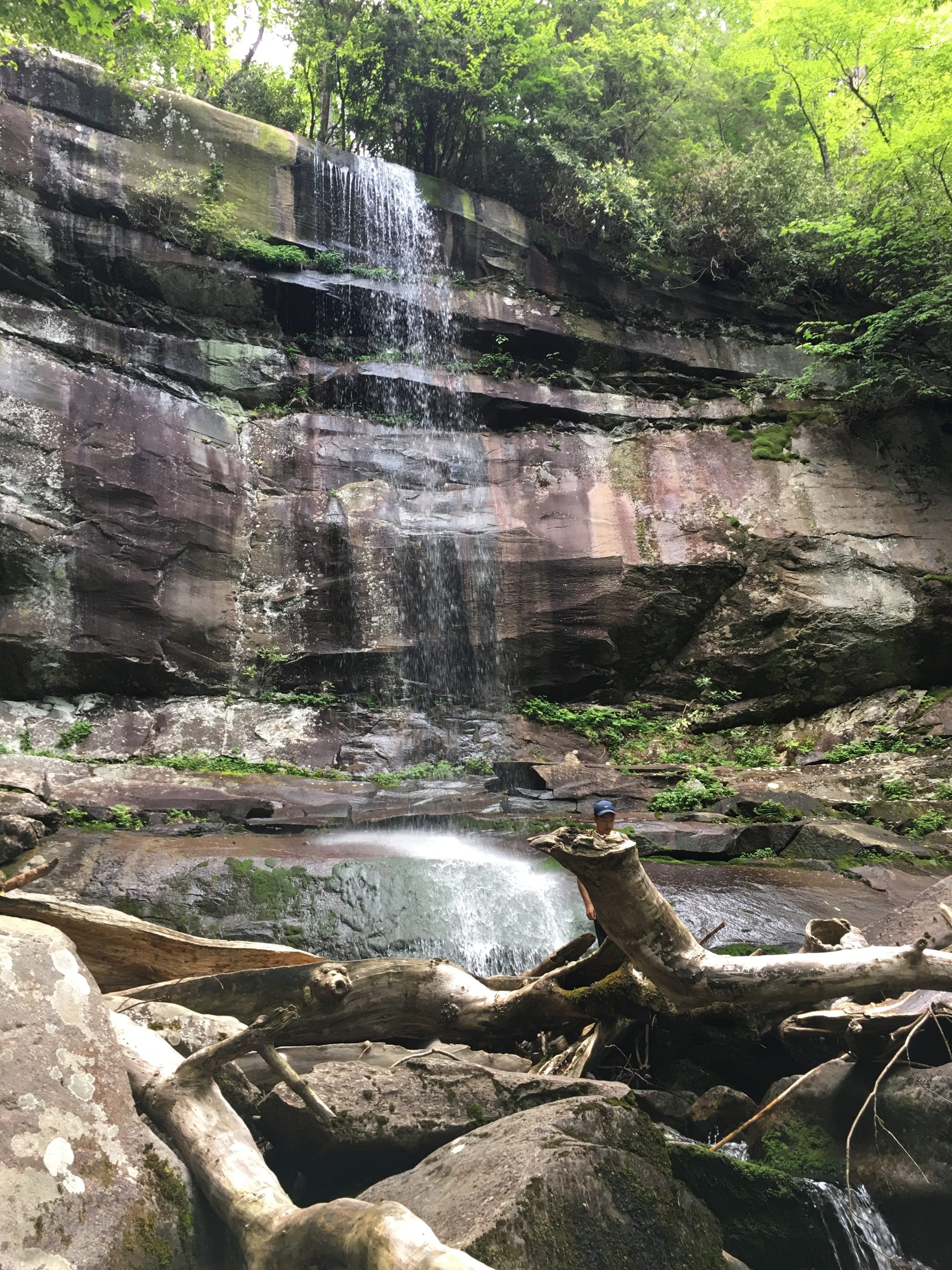 Rainbow Falls plunging 80 feet over a dark rock ledge into a boulder-strewn pool below