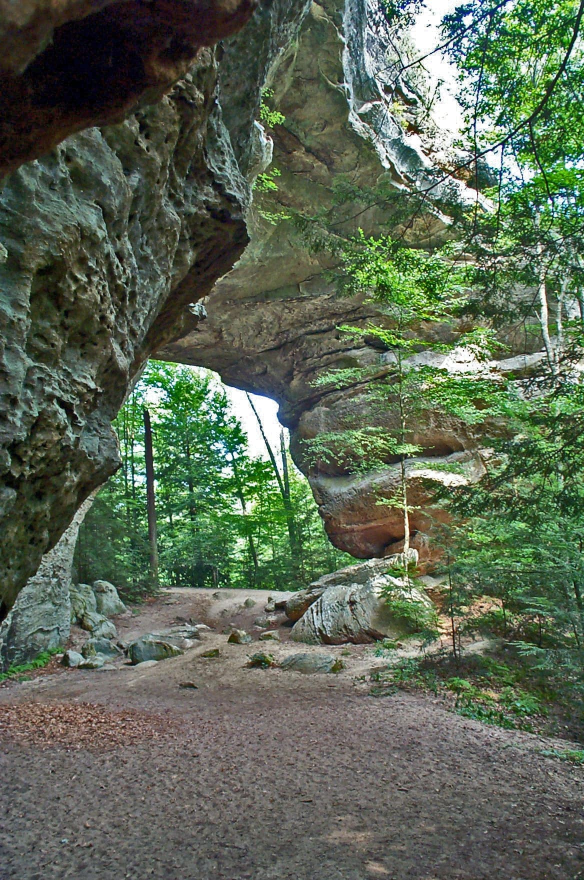 The trail passing beneath the massive sandstone span of the South Arch at Twin Arches
